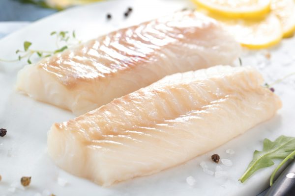 Fresh fish, raw cod fillets with addition of herbs and lemon.